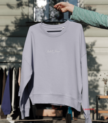 Lila mikina s nápisem „batch brew“ z legendární kafíčkové kolekce Café Jen, vyšitá bílou nití, vyfocená venku na ramínku.