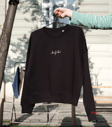 Černá mikina s nápisem „kafíčko“ z legendární kafíčkové kolekce Café Jen, vyšitá bílou nití, vyfocená venku na ramínku.